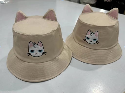 Two fun hats with cat ears and an embroidered figure of a cat in comic style